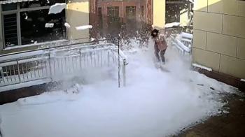 فرار یک زن در چین از سقوط برف از پشت بام ساختمان + فیلم